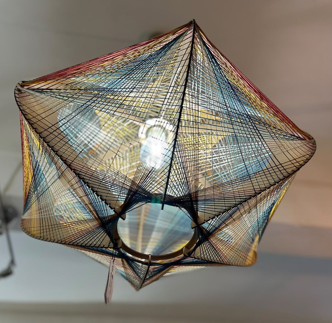 Luminaire en étoile de fils colorés vu de dessous