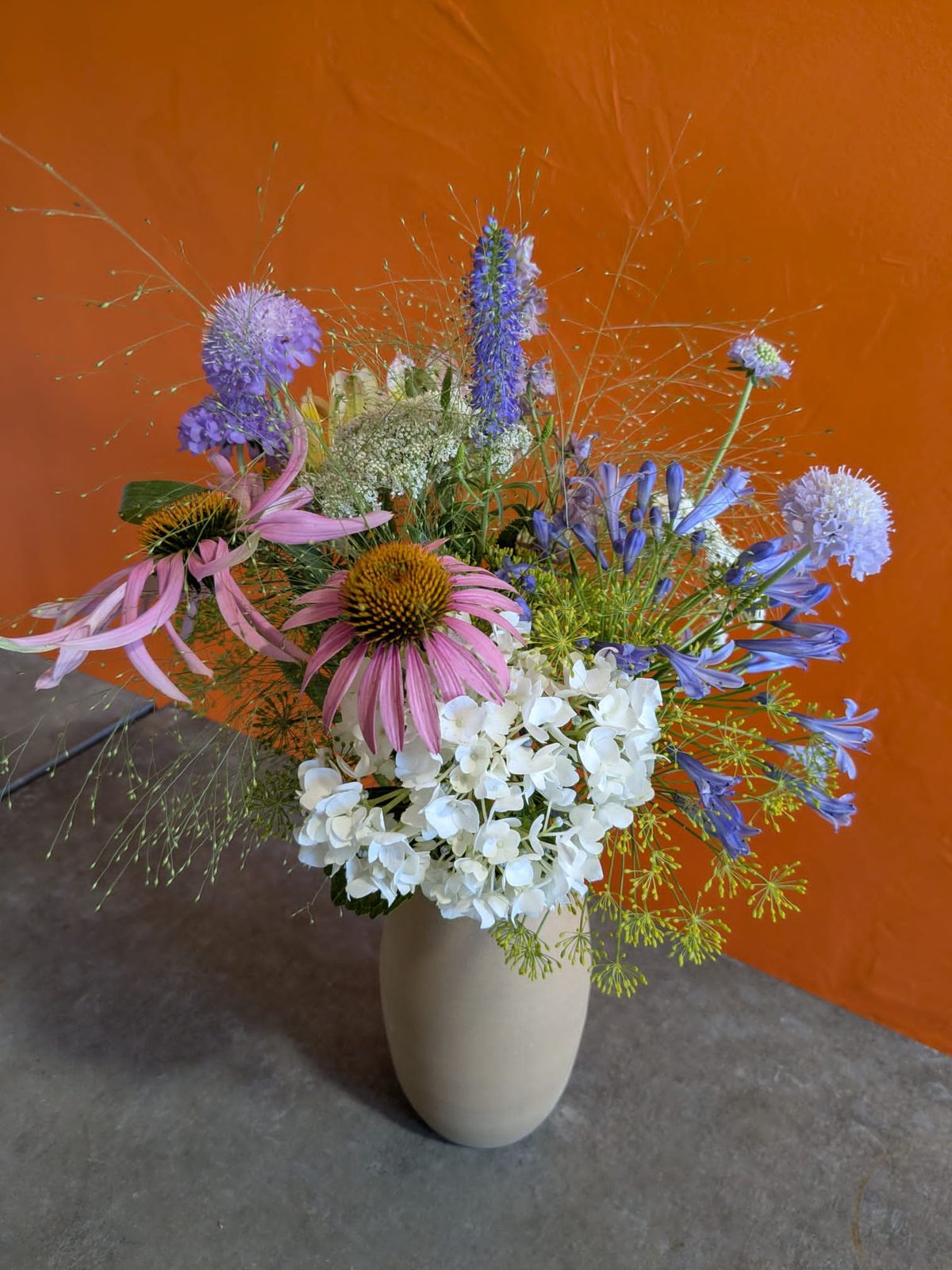 Vase en grès garni d'un bouquet de fleurs des champs